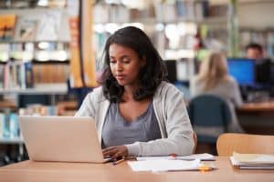 Young woman using a laptop in a library.