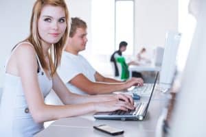 Students using a computer in a room.