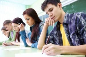 Students taking an exam in a desk.