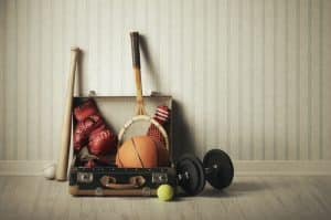 Old suitcase with sports equipments.