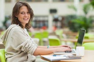 View of a woman using a laptop on a table.