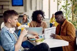 Three students talking in a table.