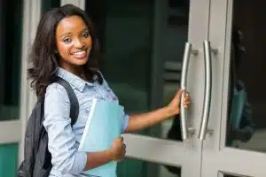 Smiling woman opening the door of a building.