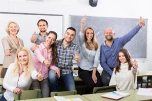 Students smiling at the camera in a classroom.