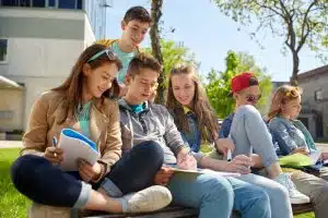 Students reading in a bench in the school campus.