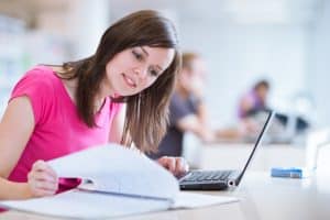 Young woman smiling while attending an online course.