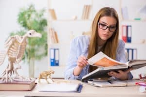 A female veterinary medicine student reading through a book in her room