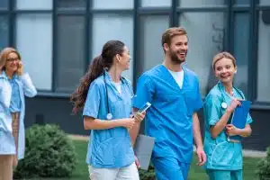 medical students wearing scrubs, talking and laughing