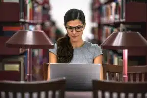 a female pre law student using her laptop inside the library