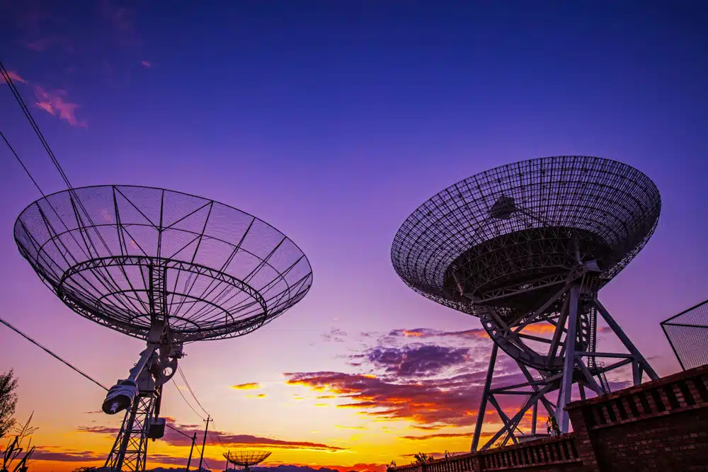 View of a radio telescope at sunset.