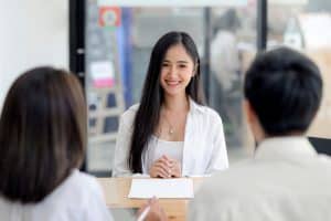 Young woman talking to two inteviewers.