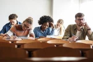 Group of students writing on their desks.