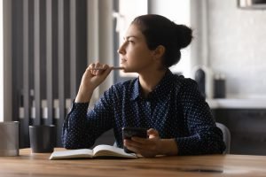 a female student sitting and appears to be thinking