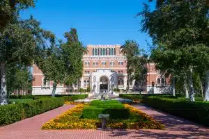 Front yard of University of Southern California sprawled with trees and that shows its main building