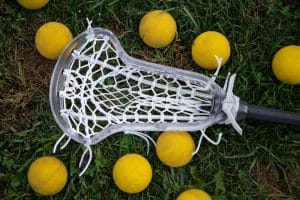 Lacrosse stick and equipment placed on the ground.