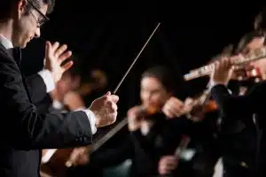 an orchestra conductor leading a group of musicians