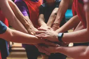 a group of athlete putting their hands together