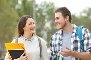 Two students holding their school books while walking in the campus.