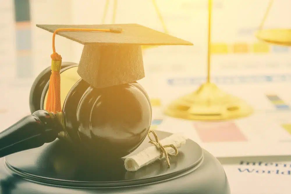 View of a graduation cap placed on top of a gavel.