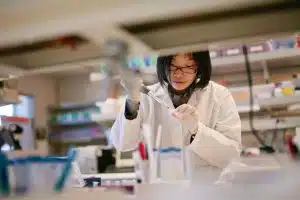 a female biomedical engineer working with a specimen inside a laboratory