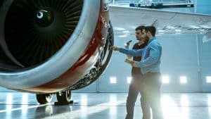 two aerospace engineers working on an airplane's turbo engine