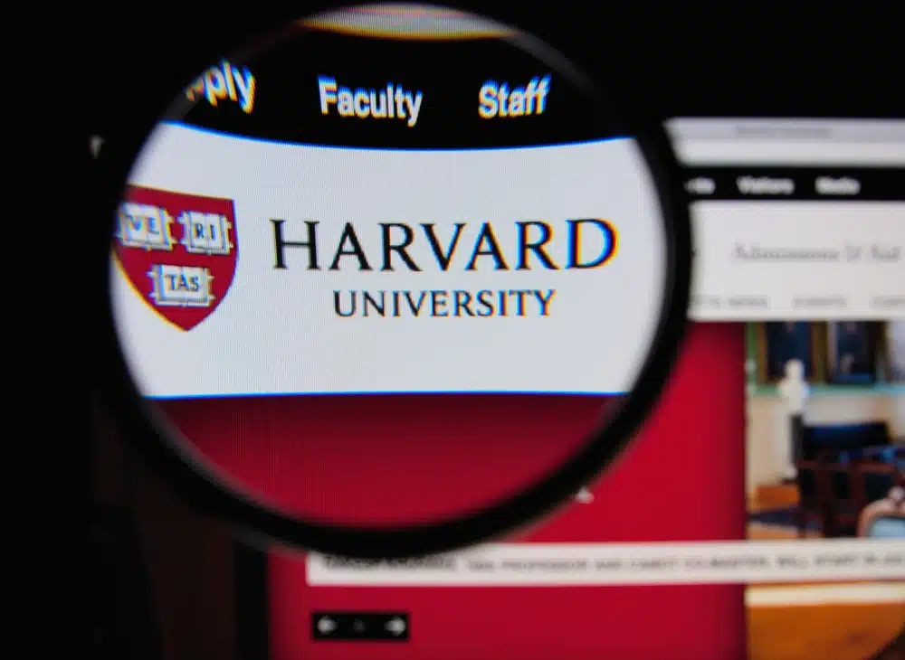 The Harvard University name flashed unto a screen and is magnified