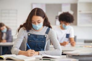 A female student taking a test and wearing a face mask