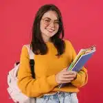 A female student smiles at the camera for Curieux Academic Journal.