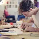 View of a student drawing on a table.