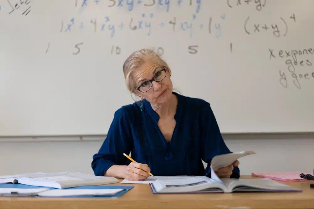 Female professor sitting on a classroom.