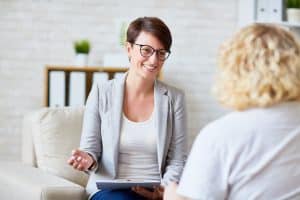 A Psychologist talking to a client in a room .