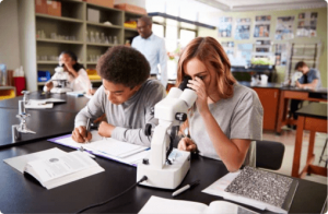 a woman looking at a microscope and a man writing notes