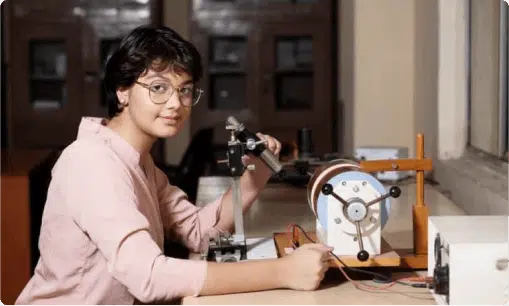 a male student holding something while looking at the camera