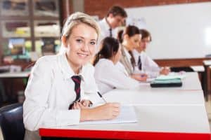 Female student writing in the classroom.