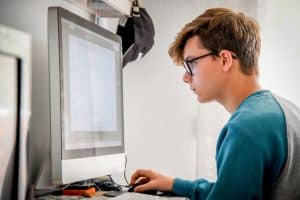 a homeschooled male teen using his personal computer