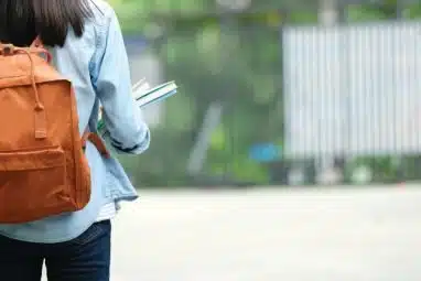 a college student carrying a back pack