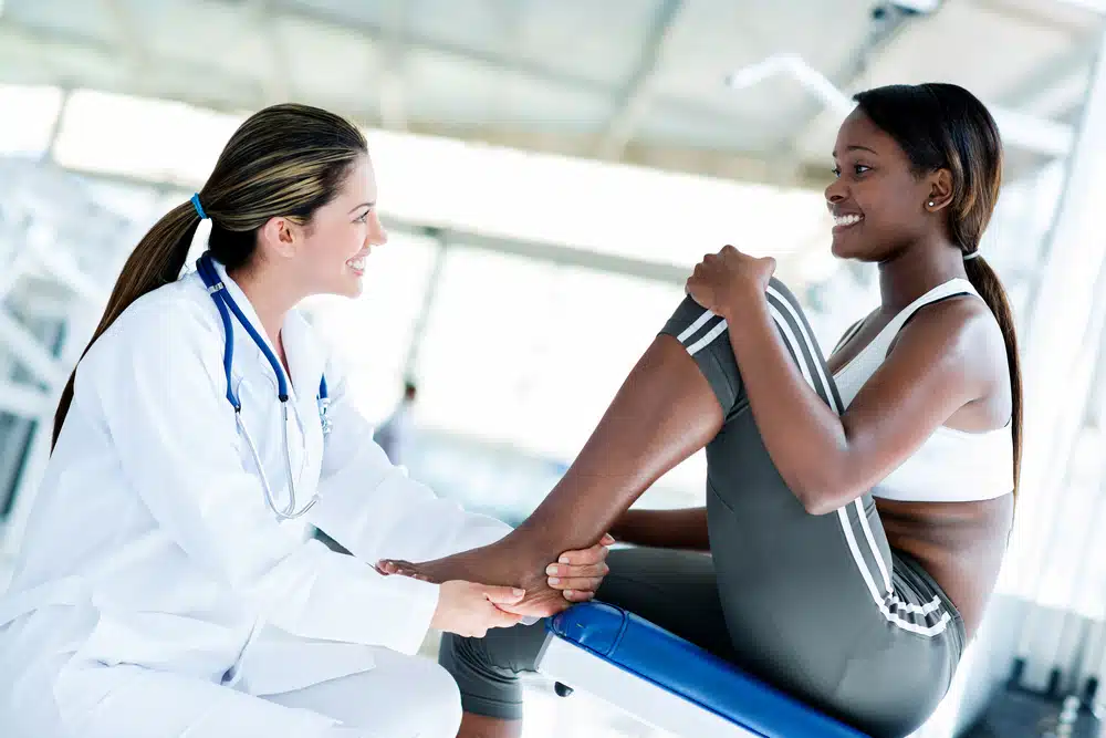 a female sports doctor treating a female athlete