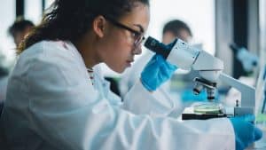 Young woman using a microscope to analyze a specimen.