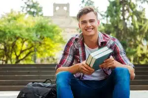 a male student sitting and looking at the camera