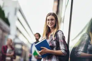 Young woman standing next to a wall.