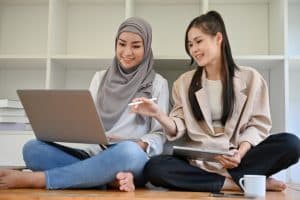 Two women talking in front of a laptop about dartmouth requirements