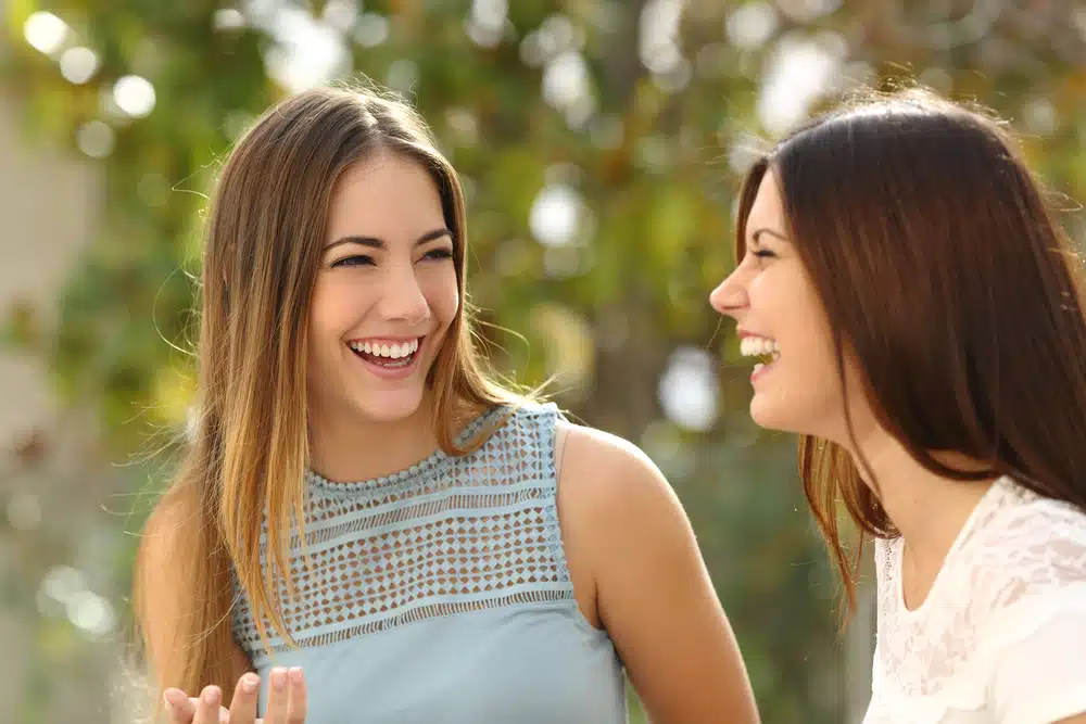Two women talking while laughing.