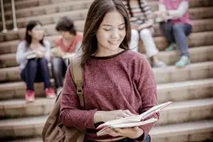 a high school student carrying her notebooks