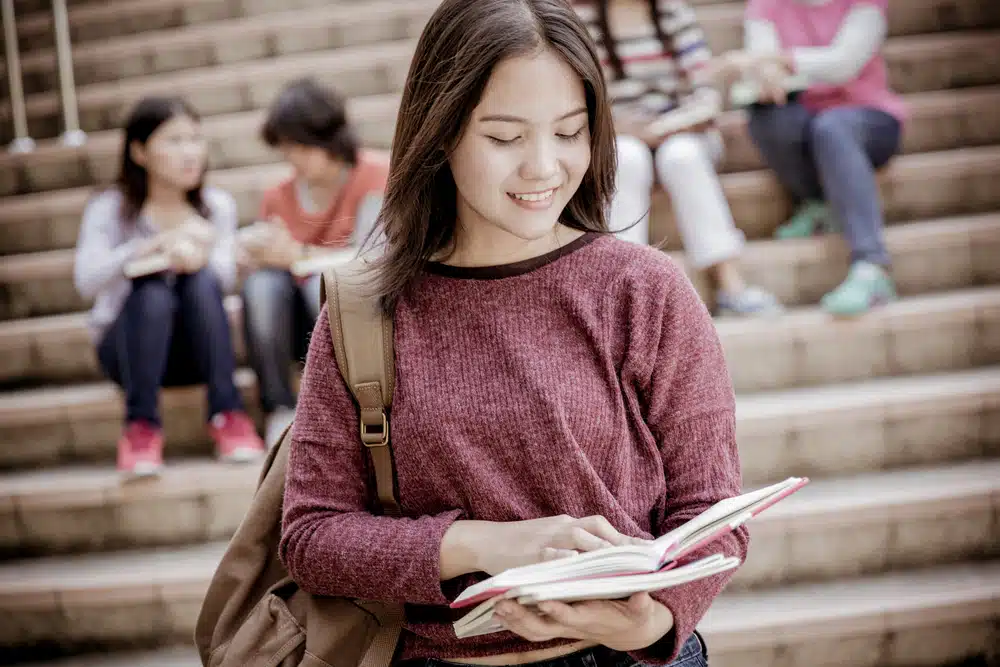 a female high school student reading her book
