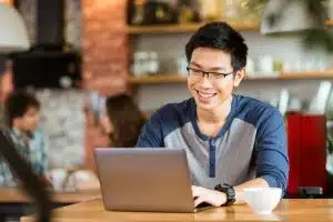 Young man using a laptop in a table.