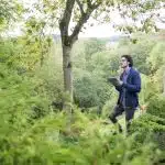 A male student observing nature to practice for environmental science competitions for high school students.