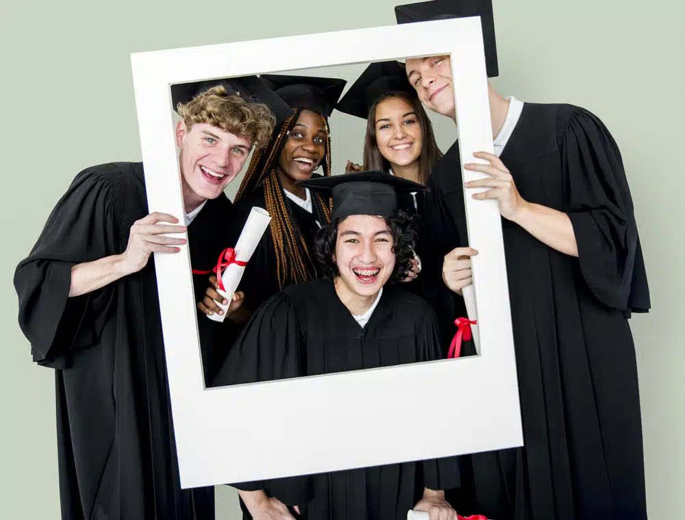 a group of high school student wearing their graduation toga and posing for a photo