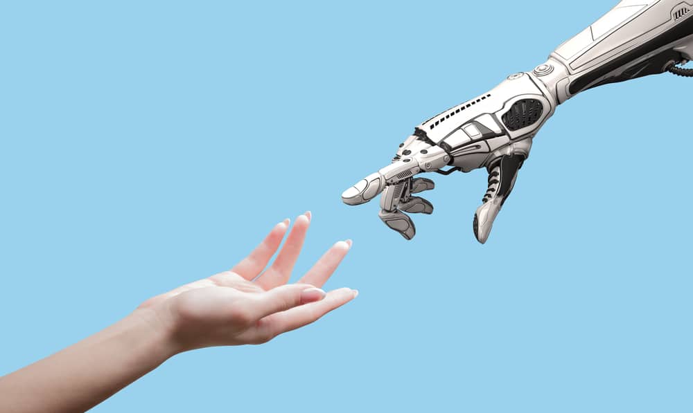 Human hand reaching out to a robot hand.