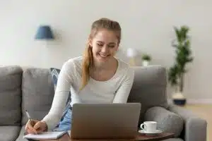 Female student writing in front of her computer.