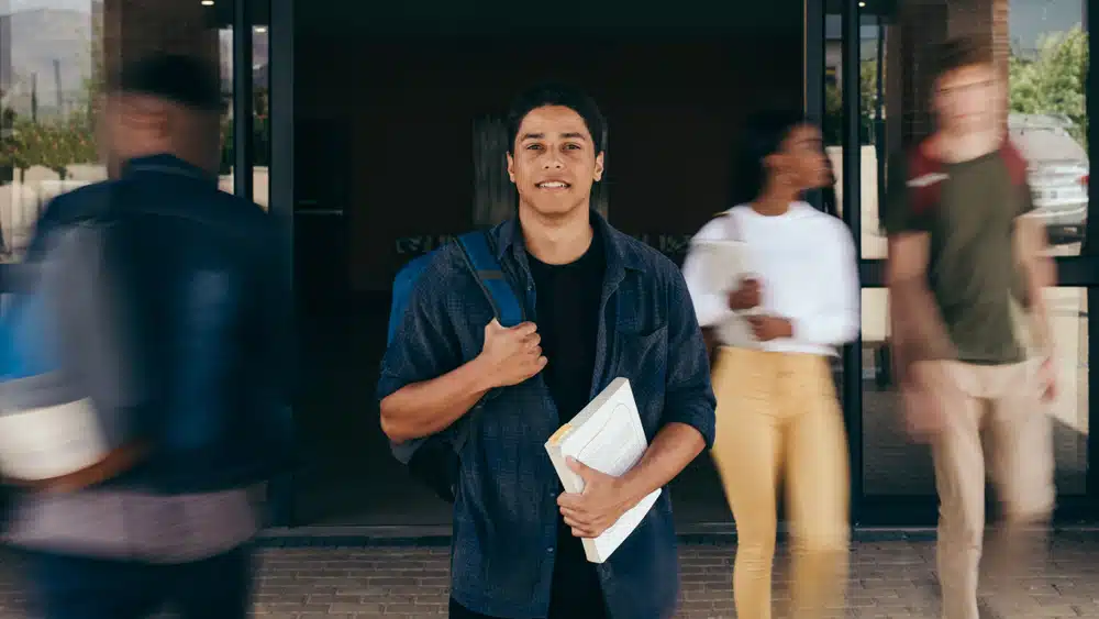 a male student standing in front of a lobby
